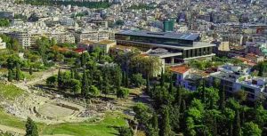 View from the hill over trees and modern buildings in Koukaki